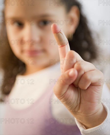 Hispanic girl with bandage on finger