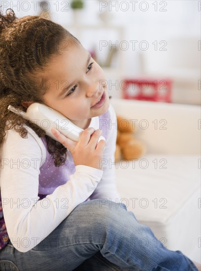 Hispanic girl talking on telephone