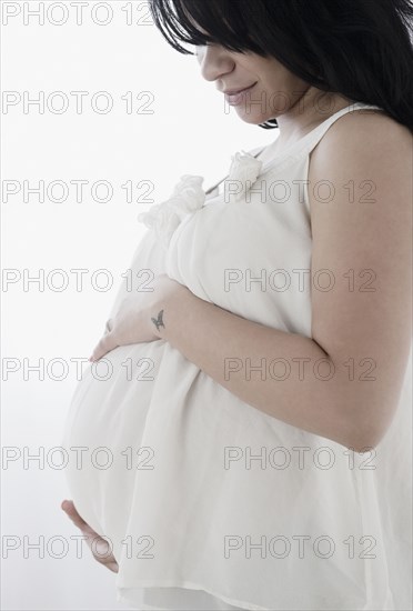 Pregnant Hispanic woman holding stomach