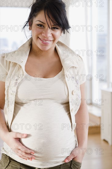 Pregnant Hispanic woman holding stomach