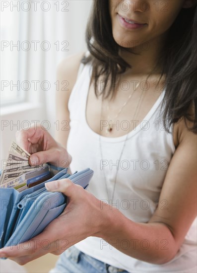 Mixed race woman taking money from wallet