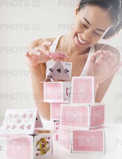 Mixed race woman building house of cards