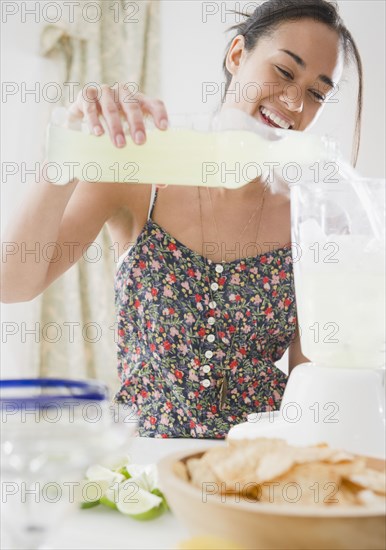 Mixed race woman mixing cocktails