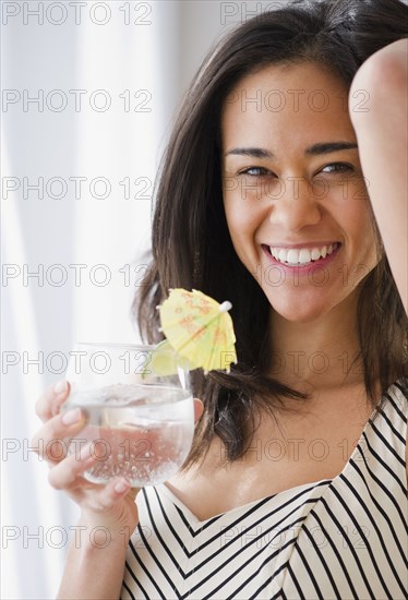 Mixed race woman drinking cocktail