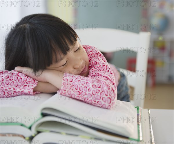 Chinese girl napping on textbooks