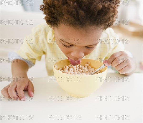 Black boy eating bowl of cereal