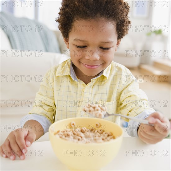 Black boy eating bowl of cereal