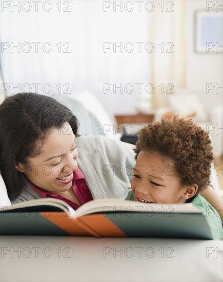 Mixed race mother reading book to son