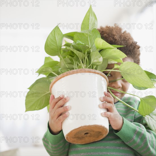 Black boy carrying potted plant