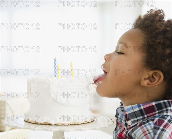 Black boy licking birthday cake