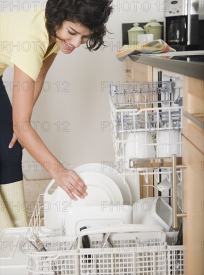 Hispanic woman putting dishes in dishwasher