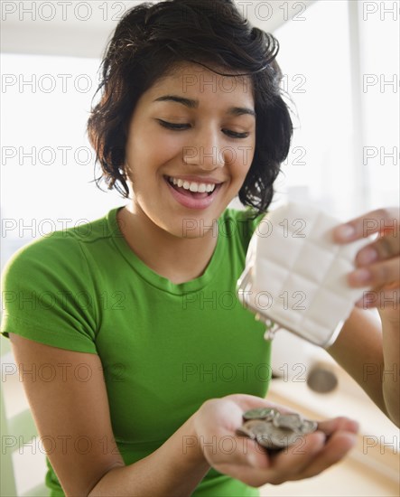 Hispanic woman emptying coin purse