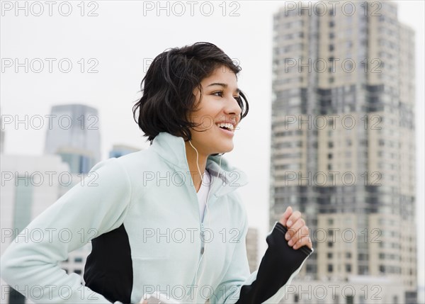 Hispanic woman running in city