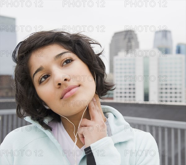 Hispanic woman checking pulse in city