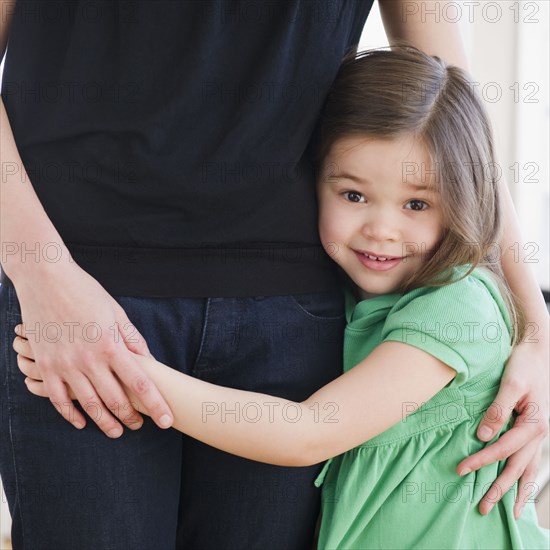 Mixed race girl hugging mother