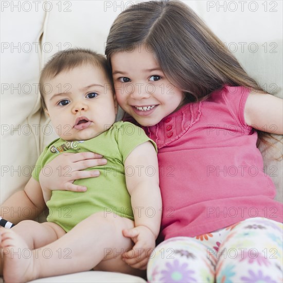 Mixed race girl hugging brother