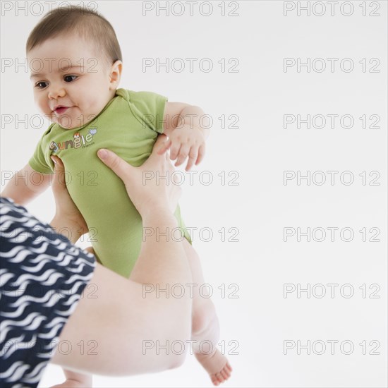 Mother lifting mixed race baby boy