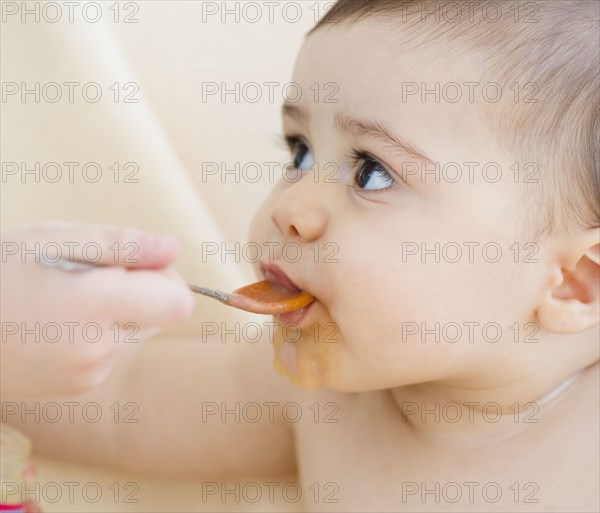 Mixed race baby boy eating