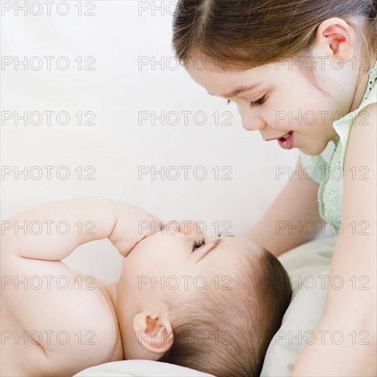 Mixed race girl talking to baby brother