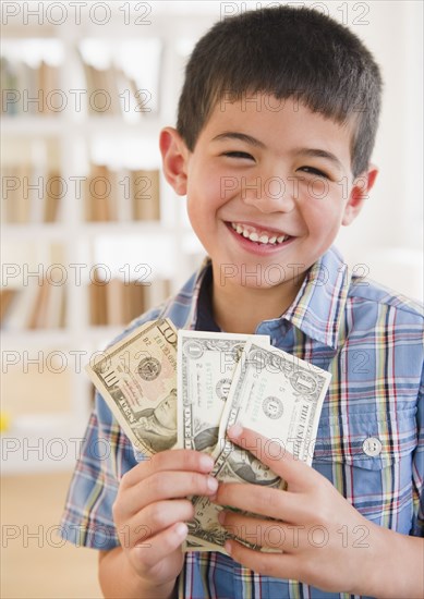 Mixed race boy holding money