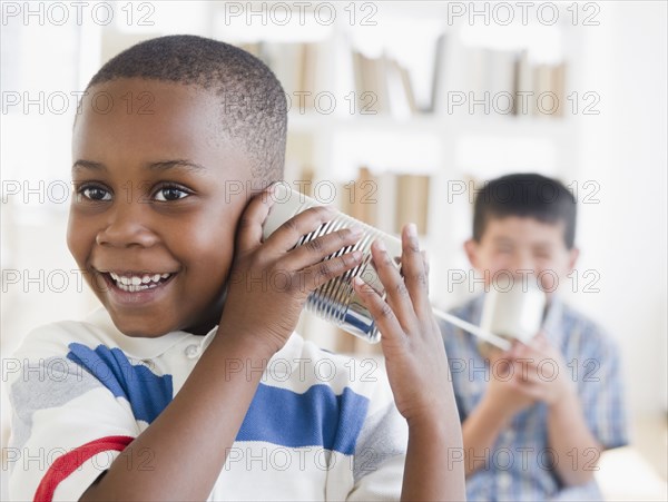 Boys playing with tin can telephone