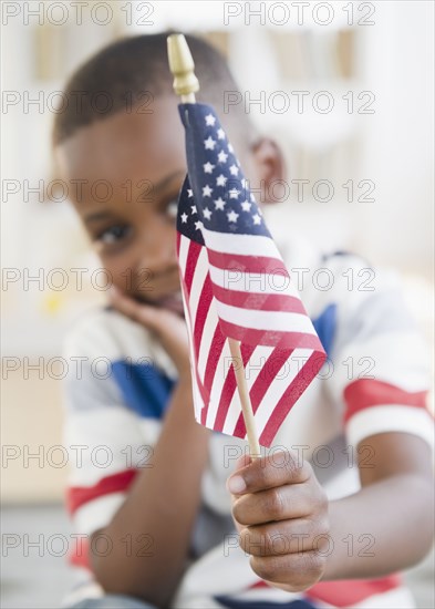 Black boy holding small American flag