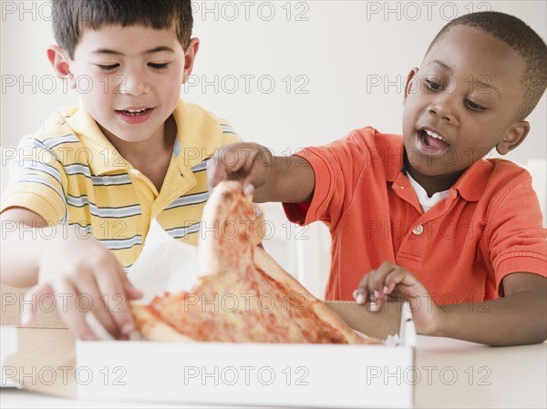 Boys eating pizza together