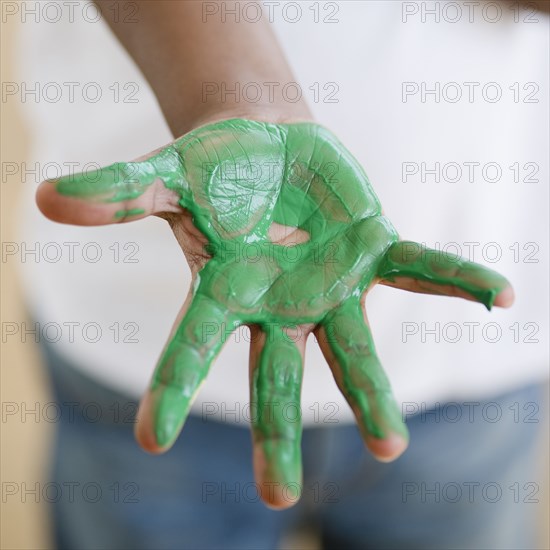 Black boy with green paint on hand