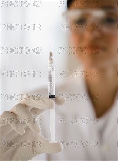 Mixed race doctor holding syringe