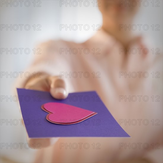 Mixed race woman giving valentine card