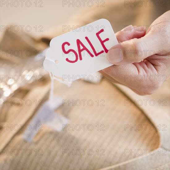 Hand holding clothing sale tag