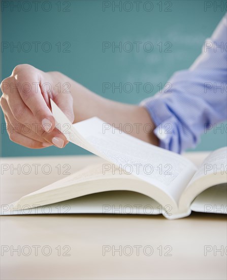 Hand turning page in book