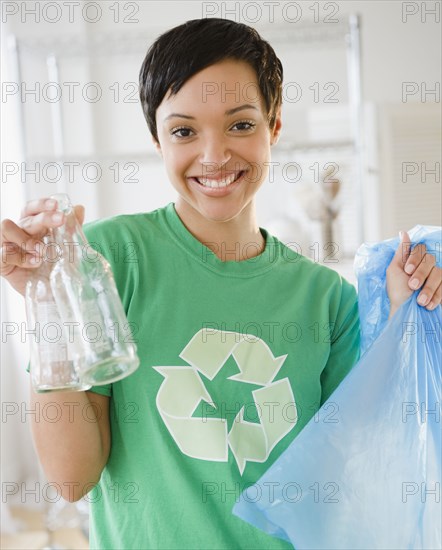 Mixed race woman recycling bottles