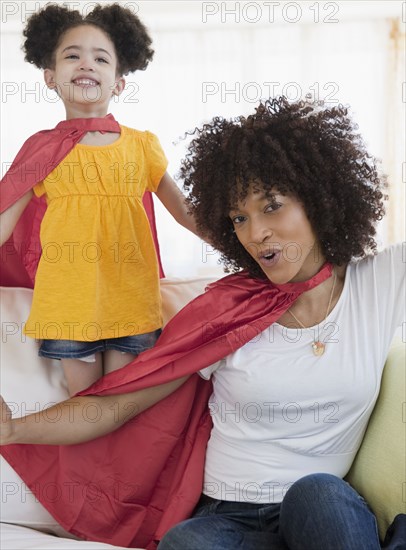 Mother and daughter wearing superhero capes