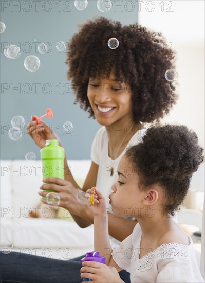 Mother and daughter blowing bubbles