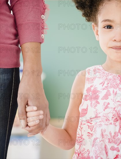 Woman and girl holding hands