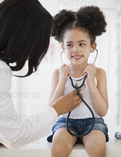Pediatrician helping patient listen to heartbeat