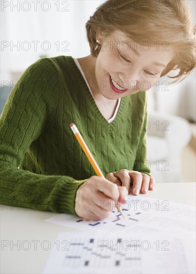 Japanese woman solving crossword puzzle