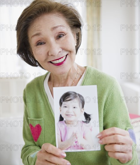Japanese woman holding photograph of girl