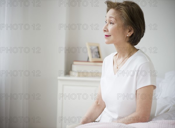 Japanese woman sitting on bed