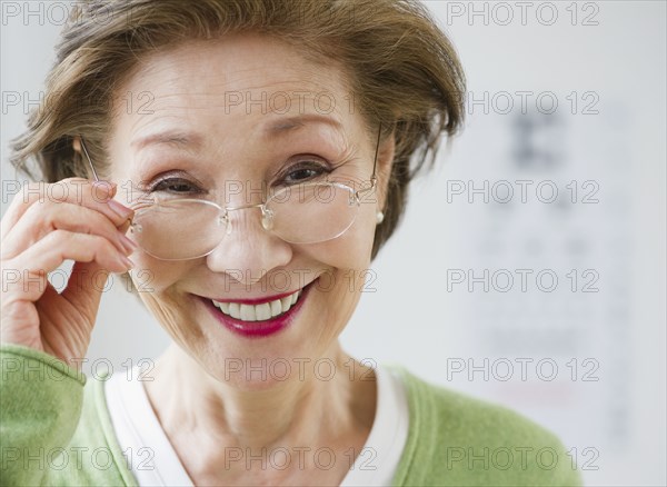 Japanese woman holding eyeglasses