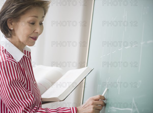 Japanese woman writing on chalk board