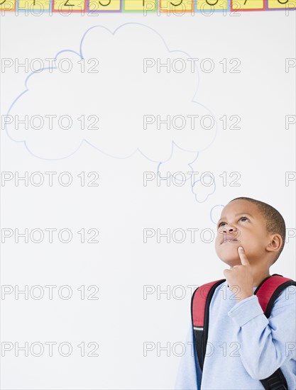 African American boy in school with thought bubble