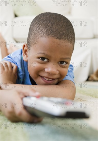 African American boy laying on floor watching television