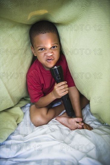 African American boy making fence in tent