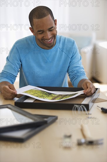 Mixed race man framing picture