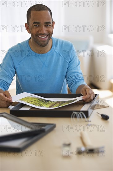 Mixed race man framing picture