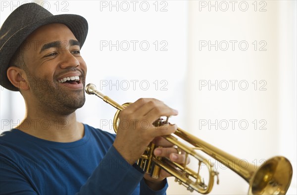 Mixed race man playing trumpet