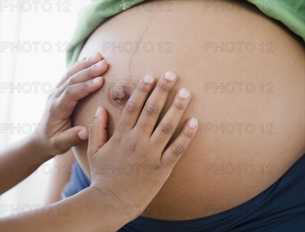 Close up of Black boy touching pregnant mother's stomach