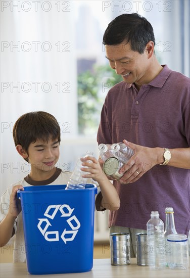 Father and son recycling plastic bottles and tin cans
